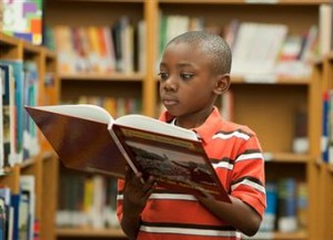 Black child reading in library