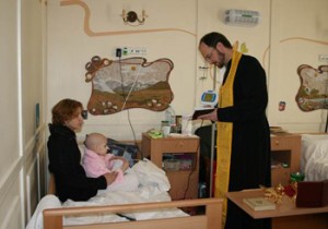 Father Alexander Tkachenko with a young patient and her mother © Aid to the Church in Need
