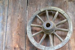 wooden wagon wheel against barn